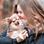 mujer con su perro en brazos